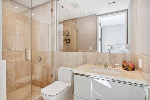 15701 Collins Ave Unit 2902, Sunny Isles Beach, FL 33160 - bathroom with vanity, a shower stall, and tile walls