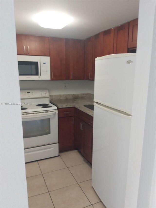 241 SE 9th Ave Unit 103, Pompano Beach, FL 33060 - kitchen featuring white appliances, light tile patterned floors, and light countertops