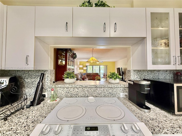 318 Lakeview Dr Unit 203, Weston, FL 33326 - kitchen featuring backsplash, white cabinets, glass insert cabinets, and light stone counters