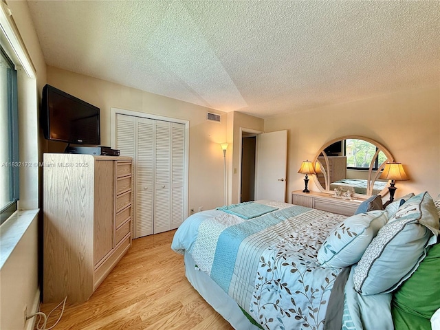 318 Lakeview Dr Unit 203, Weston, FL 33326 - bedroom with a closet, a textured ceiling, and light wood-style flooring