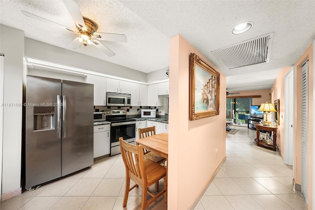 1601 SW 128th Ter Unit 209A, Pembroke Pines, FL 33027 - kitchen with stainless steel appliances, ceiling fan, light tile patterned floors, dark countertops, and a textured ceiling