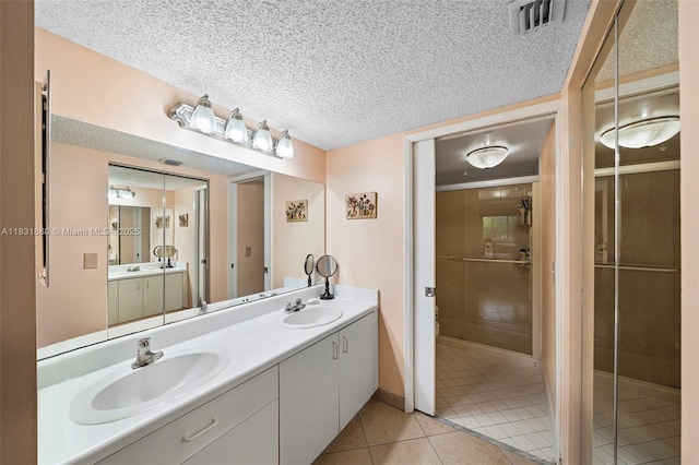 1601 SW 128th Ter Unit 209A, Pembroke Pines, FL 33027 - bathroom featuring tile patterned floors, double vanity, and a textured ceiling