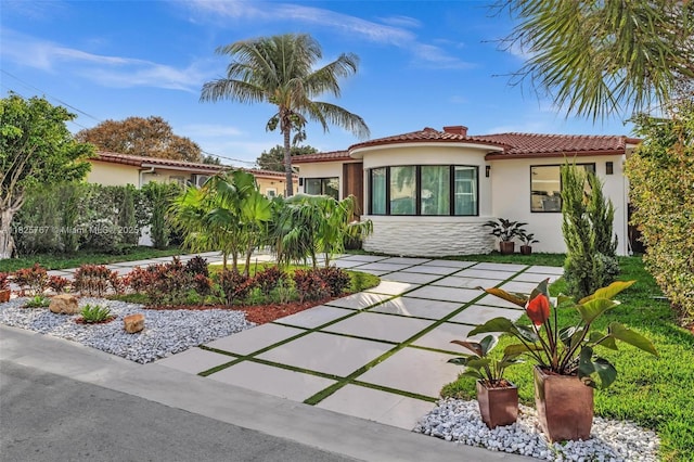 9448 Abbott Ave, Surfside, FL 33154 - mediterranean / spanish-style house with stucco siding, a tiled roof, and stone siding