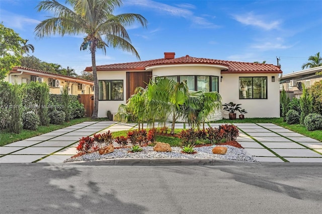 9448 Abbott Ave, Surfside, FL 33154 - mediterranean / spanish-style home featuring stucco siding, a tile roof, and a chimney