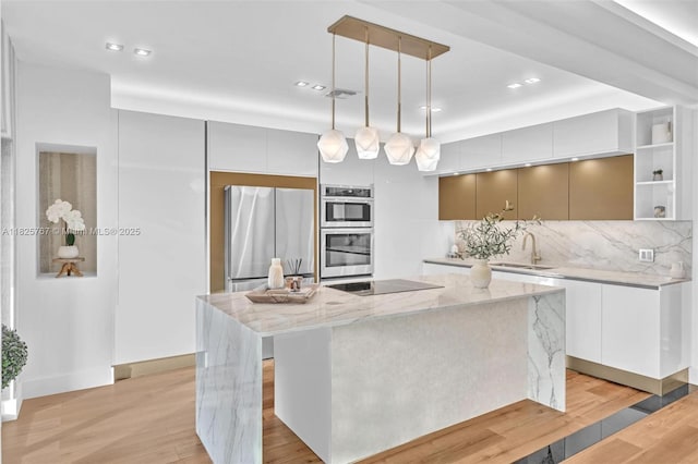 9448 Abbott Ave, Surfside, FL 33154 - kitchen with stainless steel appliances, modern cabinets, backsplash, a kitchen island, and light wood-style flooring