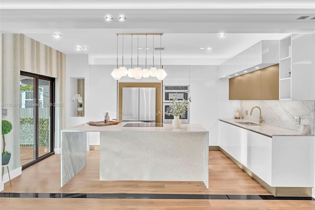9448 Abbott Ave, Surfside, FL 33154 - kitchen with stainless steel appliances, modern cabinets, light countertops, a kitchen island, and tasteful backsplash