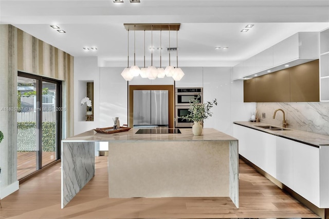 9448 Abbott Ave, Surfside, FL 33154 - kitchen with modern cabinets, stainless steel appliances, a center island, light wood finished floors, and white cabinets