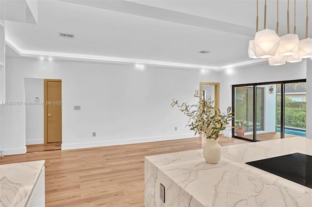 9448 Abbott Ave, Surfside, FL 33154 - kitchen with light wood-style flooring, light stone counters, decorative light fixtures, and black electric cooktop