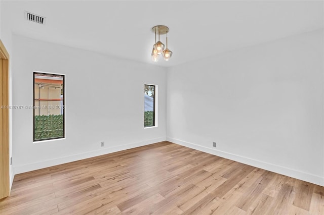 9448 Abbott Ave, Surfside, FL 33154 - spare room with light wood-style flooring and a chandelier