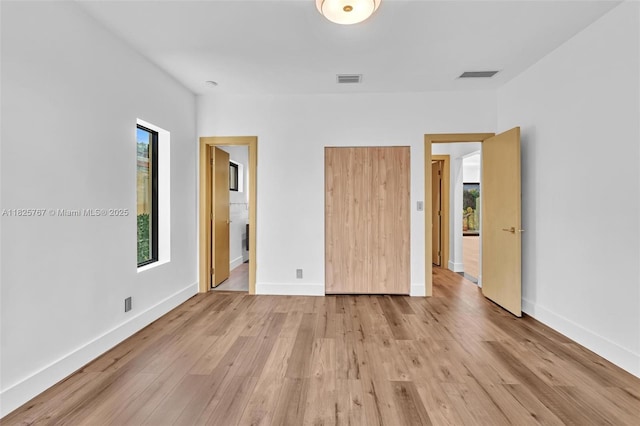 9448 Abbott Ave, Surfside, FL 33154 - unfurnished bedroom with multiple windows and light wood-style floors