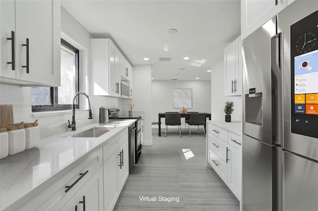 212 SW 11th Ave, Dania Beach, FL 33004 - kitchen with stainless steel appliances, white cabinetry, light stone counters, and recessed lighting
