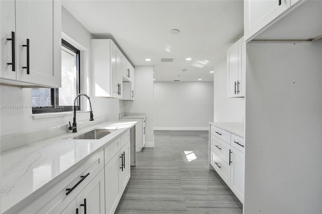 212 SW 11th Ave, Dania Beach, FL 33004 - kitchen with light stone counters, white cabinetry, and recessed lighting