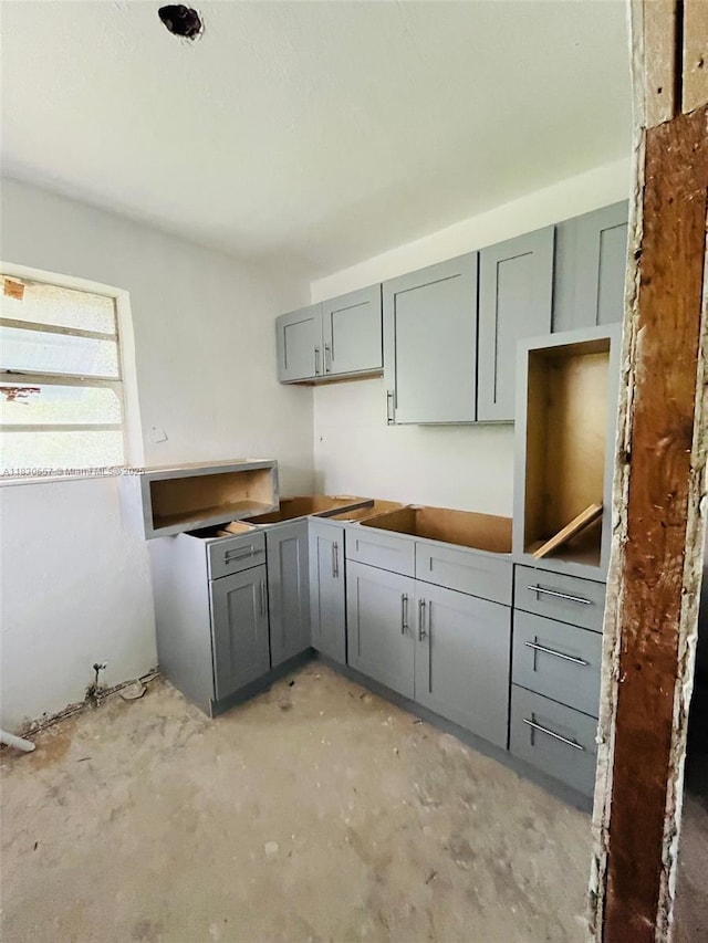 1344 W 10th St, Riviera Beach, FL 33404 - kitchen with gray cabinets and concrete floors