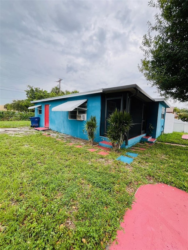 1344 W 10th St, Riviera Beach, FL 33404 - view of property exterior featuring a lawn and a sunroom