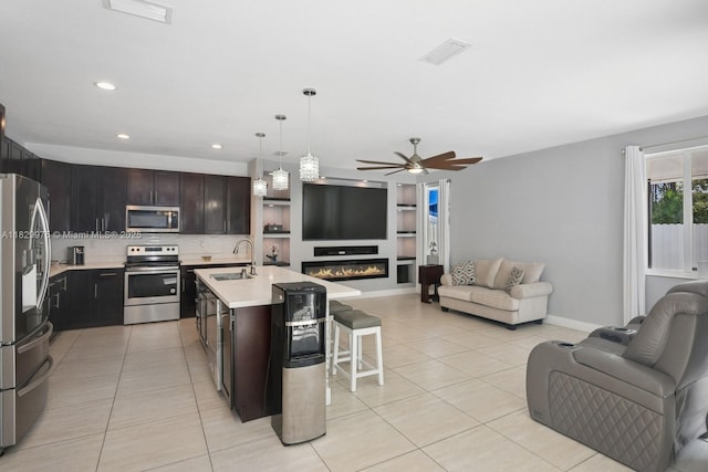 18350 SW 139th Path, Miami, FL 33177 - kitchen with stainless steel appliances, open floor plan, light tile patterned floors, light countertops, and a kitchen bar