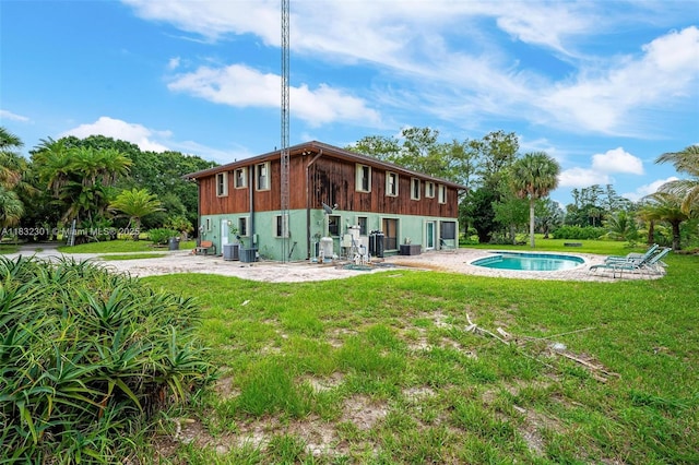 576 Marshall Rd, West Palm Beach, FL 33413 - back of property with a patio, a lawn, and an outdoor pool