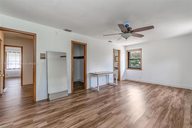 576 Marshall Rd, West Palm Beach, FL 33413 - unfurnished bedroom with wood finished floors, a walk in closet, a ceiling fan, and a closet