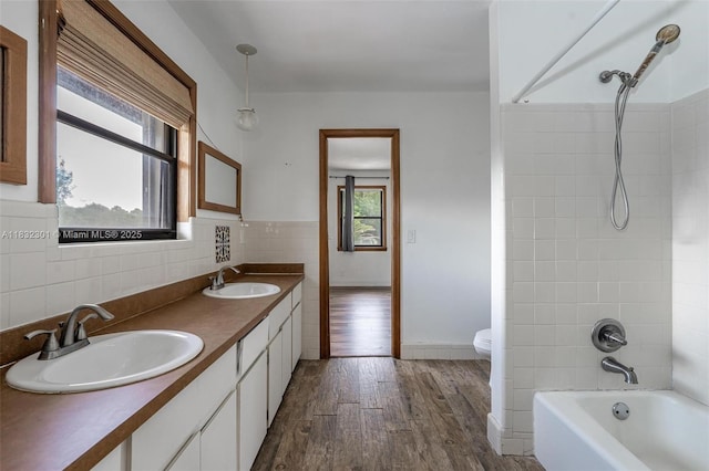 576 Marshall Rd, West Palm Beach, FL 33413 - bathroom with wood finished floors, double vanity, shower / washtub combination, and tile walls