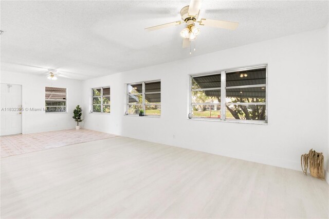 5706 NW 81st Ave, Tamarac, FL 33321 - empty room featuring a ceiling fan, wood finished floors, healthy amount of natural light, and a textured ceiling