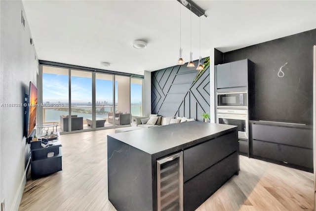 2020 N Bayshore Dr Unit 3408, Miami, FL 33137 - kitchen with a wall of windows, stainless steel oven, built in microwave, light wood finished floors, and wine cooler