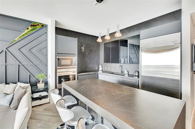 2020 N Bayshore Dr Unit 3408, Miami, FL 33137 - kitchen featuring built in appliances, a kitchen breakfast bar, modern cabinets, light wood finished floors, and open floor plan