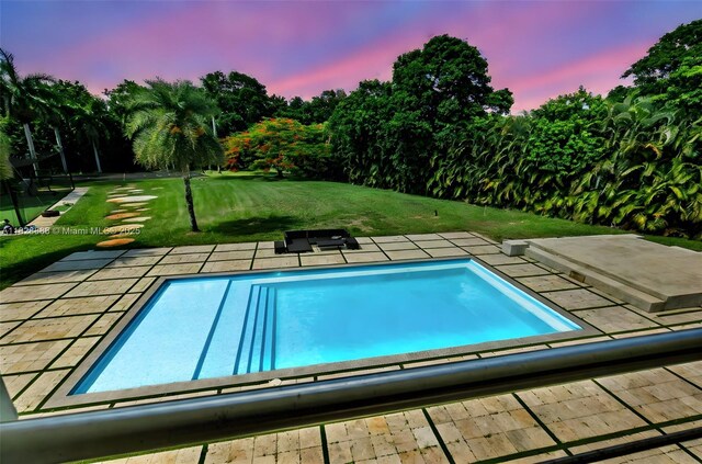 13441 Mustang Trl, Southwest Ranches, FL 33330 - pool at dusk featuring a lawn and an outdoor pool