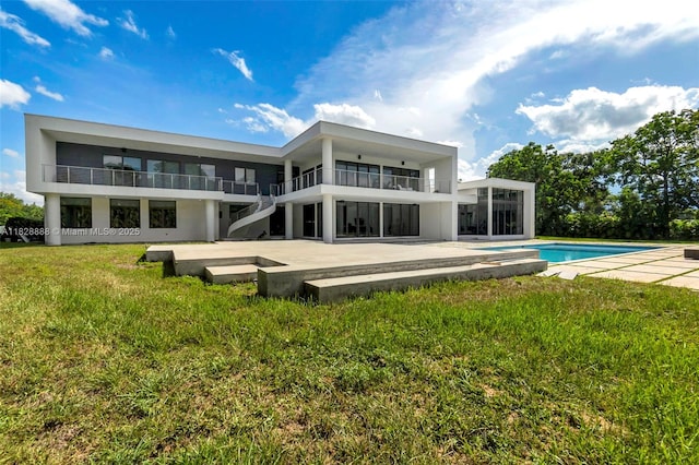 13441 Mustang Trl, Southwest Ranches, FL 33330 - back of house with a patio area, an outdoor pool, a yard, and a balcony