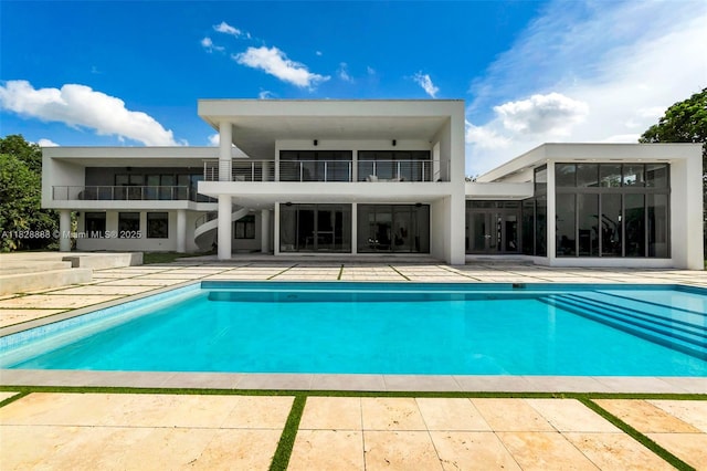 13441 Mustang Trl, Southwest Ranches, FL 33330 - back of house featuring a balcony, a patio area, an outdoor pool, and stairs