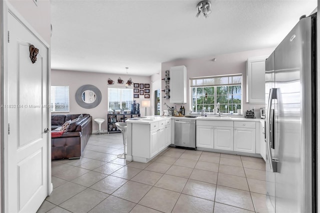 10700 NW 66th St Unit 308, Doral, FL 33178 - kitchen featuring stainless steel appliances, open floor plan, a peninsula, and healthy amount of natural light