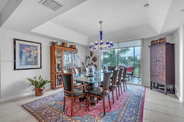 10700 NW 66th St Unit 308, Doral, FL 33178 - dining room featuring a tray ceiling, light tile patterned flooring, and a chandelier