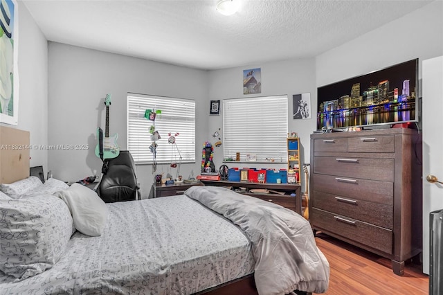 10700 NW 66th St Unit 308, Doral, FL 33178 - bedroom featuring light wood-style floors and a textured ceiling