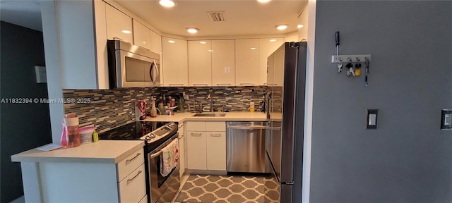 3522 NE 171st St Unit 104, North Miami Beach, FL 33160 - kitchen with stainless steel appliances, tasteful backsplash, white cabinets, light countertops, and modern cabinets
