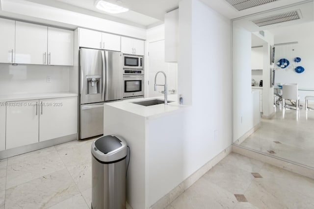 18911 Collins Ave Unit 2002, Sunny Isles Beach, FL 33160 - kitchen with stainless steel appliances, white cabinetry, light marble finish floors, and light countertops