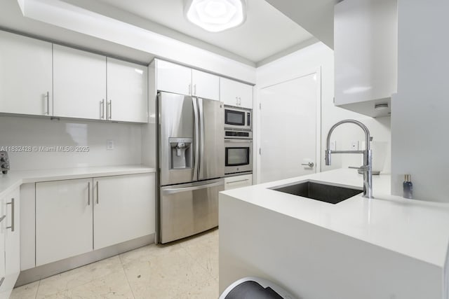 18911 Collins Ave Unit 2002, Sunny Isles Beach, FL 33160 - kitchen featuring appliances with stainless steel finishes, light countertops, white cabinets, and light marble finish floors