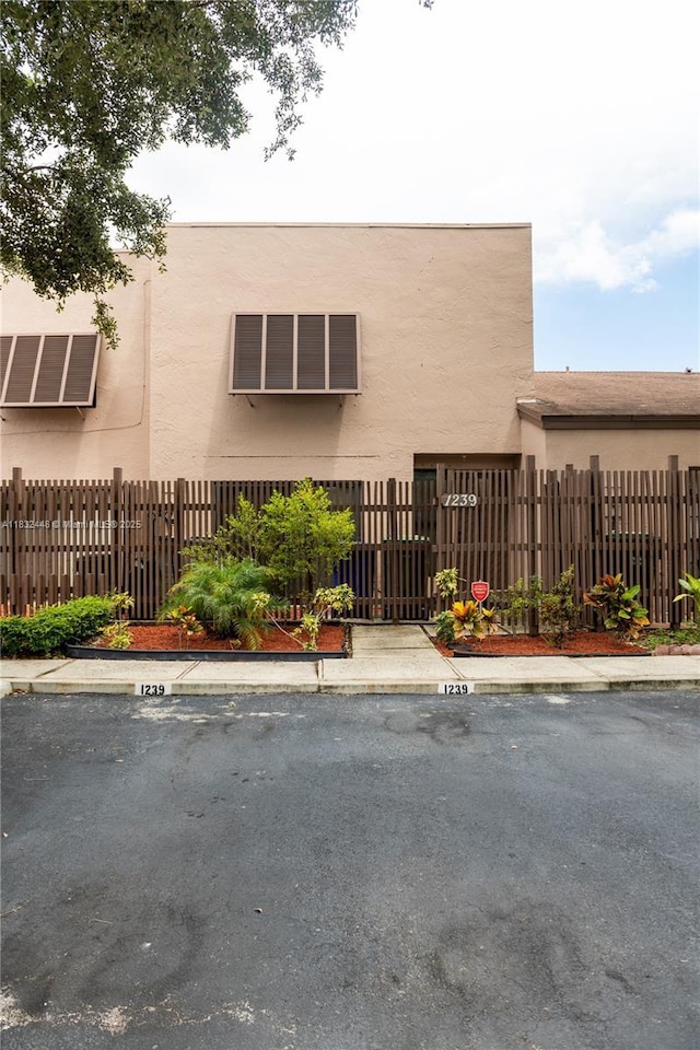 1239 NW 122nd Ter, Pembroke Pines, FL 33026 - view of building exterior with uncovered parking and a fenced front yard