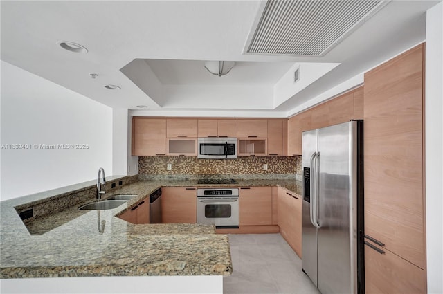 14951 Royal Oaks Ln Unit 806, North Miami, FL 33181 - kitchen with appliances with stainless steel finishes, a peninsula, a tray ceiling, stone countertops, and tasteful backsplash