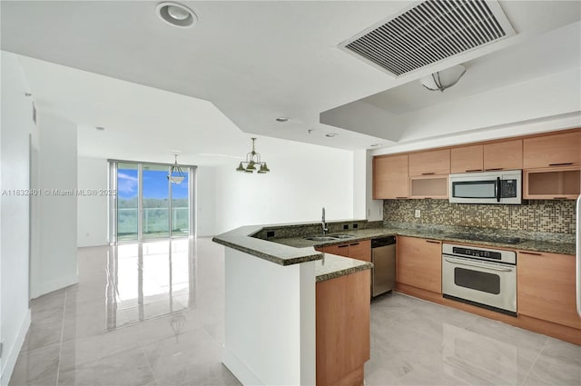 14951 Royal Oaks Ln Unit 806, North Miami, FL 33181 - kitchen featuring stainless steel appliances, a peninsula, tasteful backsplash, dark stone counters, and pendant lighting