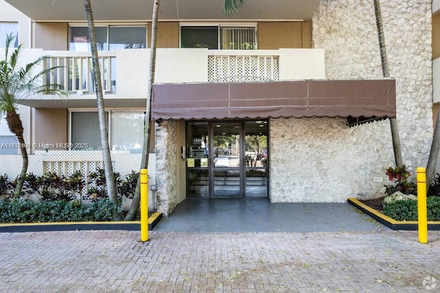 1800 Sans Souci Blvd Unit 105, North Miami, FL 33181 - doorway to property with a balcony and stucco siding