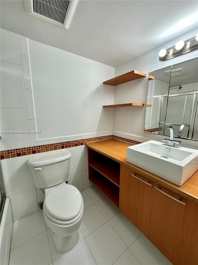 1800 Sans Souci Blvd Unit 105, North Miami, FL 33181 - full bath featuring vanity, tile walls, a wainscoted wall, tile patterned floors, and a textured ceiling