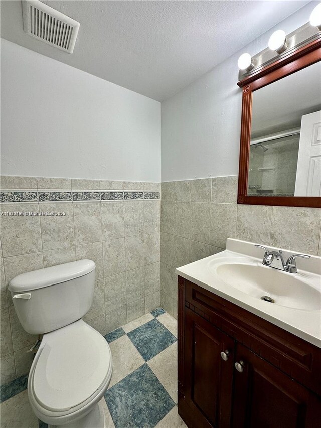 1800 Sans Souci Blvd Unit 105, North Miami, FL 33181 - full bath featuring tile walls, vanity, wainscoting, and a textured ceiling
