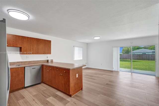 12254 SW 217th St, Miami, FL 33170 - kitchen with stainless steel dishwasher, a peninsula, brown cabinetry, and a textured ceiling
