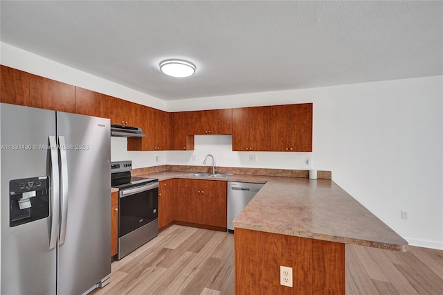 12254 SW 217th St, Miami, FL 33170 - kitchen featuring stainless steel appliances, a peninsula, under cabinet range hood, and light wood-style floors