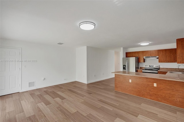 12254 SW 217th St, Miami, FL 33170 - kitchen featuring electric stove, stainless steel refrigerator with ice dispenser, under cabinet range hood, brown cabinetry, and light wood-style floors