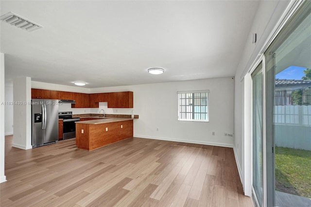 12254 SW 217th St, Miami, FL 33170 - kitchen with stainless steel appliances, a peninsula, open floor plan, light wood finished floors, and brown cabinetry