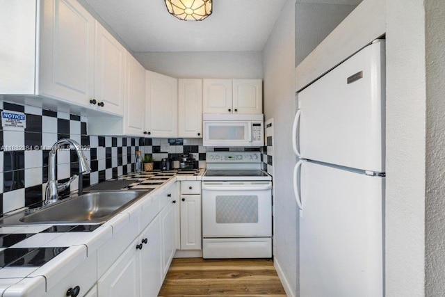 505 SE 20th St, Fort Lauderdale, FL 33316 - kitchen featuring white appliances, tile countertops, white cabinetry, and decorative backsplash