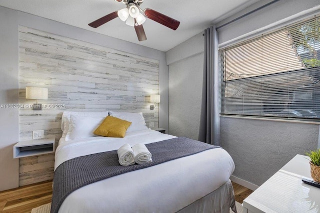 505 SE 20th St, Fort Lauderdale, FL 33316 - bedroom with wood finished floors, multiple windows, ceiling fan, and wood walls