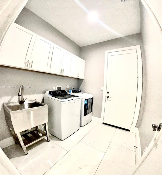 1013 SW Deauville Ave, Port St Lucie, FL 34953 - laundry room featuring washer and clothes dryer, cabinet space, and light marble finish flooring