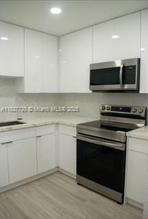 972 N 18th Ct, Hollywood, FL 33020 - kitchen featuring stainless steel appliances, white cabinetry, light countertops, and recessed lighting