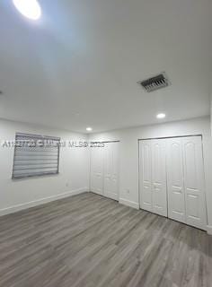 972 N 18th Ct, Hollywood, FL 33020 - unfurnished bedroom with wood finished floors, multiple closets, and recessed lighting