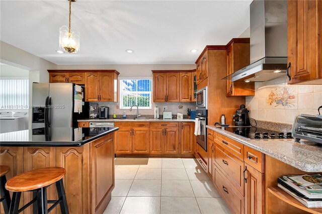 1315 W 79th St, Hialeah, FL 33014 - kitchen featuring stainless steel appliances, wall chimney range hood, brown cabinetry, decorative backsplash, and recessed lighting